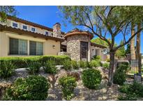Stunning exterior of home with stone turret, well-manicured landscaping, and mature tree at 8010 Palm Cove Ct, Las Vegas, NV 89129