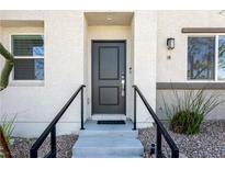 Inviting front entrance featuring a stylish black door, concrete steps, and sleek black railings at 12237 Plum Mist Ct # 4, Las Vegas, NV 89183
