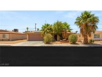 Charming single-story home with desert landscaping, a two car garage, and mature palm trees at 1901 Manhattan Dr, Las Vegas, NV 89106