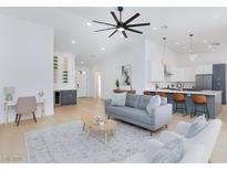Bright open-concept living room with modern furnishings and a view of the kitchen at 2475 Sedona Cedar Ave, Henderson, NV 89052