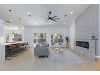 Bright living room boasts modern fireplace, sleek ceiling fan, and opens to outdoor space at 2475 Sedona Cedar Ave, Henderson, NV 89052