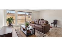 Bright living room featuring a large window, modern floors, and comfortable brown leather sofa at 2845 Loveland Dr # 3615, Las Vegas, NV 89109