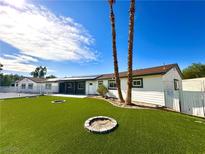 A well-manicured backyard with artificial turf and two fire pits enhances this home's outdoor appeal at 2903 Hardin Dr, Henderson, NV 89074