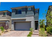Two-story home with gray stucco, brick accents, and a two-car garage at 312 Wind Poppy St, Las Vegas, NV 89138
