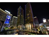 Stunning night view of the modern high-rise with illuminated signage and beautiful landscaping at 3722 Las Vegas Blvd # 2512 E, Las Vegas, NV 89158