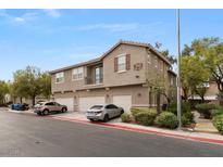 Three-story townhome with a tan exterior, red tile roof and three garages in a well maintained community at 390 Clarence House Ave # 1, North Las Vegas, NV 89032
