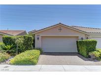 Beige one-story home with a two-car garage, desert landscaping and a tile roof under a clear blue sky at 4672 Regalo Bello St, Las Vegas, NV 89135