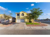 Charming two-story home featuring a two-car garage, manicured lawn, and beautiful landscaping at 5907 Soft Mist Ct, Las Vegas, NV 89110