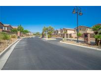 Gated community entrance featuring manicured landscaping and well-maintained asphalt roads at 6429 Joshuaville Dr, Las Vegas, NV 89122