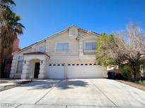 Two-story home with a stucco facade, arched entry, and an attached two-car garage at 6608 Buried Treasure Ct, Las Vegas, NV 89139