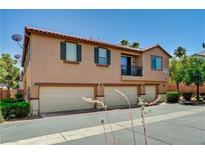 Lovely exterior view of a multi-Gathering townhouse with a terra cotta tile roof and three garages at 9115 Canoga Canyon Ct # 103, Las Vegas, NV 89149