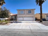 Two-story home with a wide driveway and a two-car garage under a clear, sunny sky at 9693 Bighorn Island Ave, Las Vegas, NV 89148