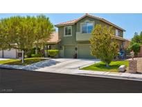 Charming two-story home featuring a spacious driveway, mature landscaping, and a well-maintained lawn at 9909 Masked Duck Ave, Las Vegas, NV 89117