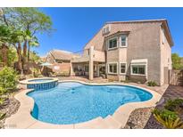 Inviting backyard oasis with pool, hot tub, and outdoor kitchen perfect for entertaining at 11219 Playa Bonita Ave, Las Vegas, NV 89138
