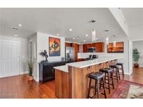 Open kitchen featuring hardwood floors, stainless steel appliances, and a breakfast bar with seating at 150 Las Vegas Blvd # 1906, Las Vegas, NV 89101