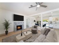 Bright living room featuring a stone fireplace, ceiling fan, and an open floorplan at 1700 Sweeney Ave, Las Vegas, NV 89104