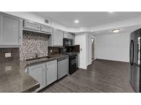 This kitchen features gray cabinets, stainless steel appliances, and a tile backsplash at 3944 Visby Ln, Las Vegas, NV 89119
