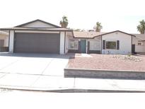 Charming single-story home with a gray garage door and desert landscaping at 4277 Rimcrest Rd, Las Vegas, NV 89121