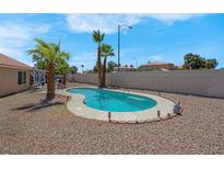 Backyard swimming pool with desert landscaping, mature palms, and privacy walls at 5033 Austrian Dr, Las Vegas, NV 89130