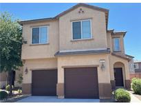 Two-story home featuring a two car garage, landscaped yard, and classic desert architecture at 664 Forest Peak St, Henderson, NV 89011