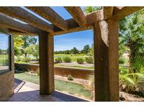 View of golf course from covered back patio with desert landscaping and beautiful pergola at 7132 Mission Hills Dr, Las Vegas, NV 89113