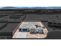 Newly constructed home features a desert landscape, with stone accents, a paved driveway and a spacious two-car garage at 7141 Painted Skyline St, Las Vegas, NV 89118