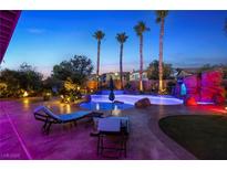 Inviting outdoor oasis featuring a large swimming pool with rock features and swaying palm trees, perfect for relaxation and entertainment at 741 Canary Wharf Dr, Las Vegas, NV 89178
