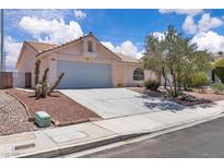 Charming single-story home showcasing a two-car garage and beautiful landscaping with a quaint front yard at 918 Ambusher St, Henderson, NV 89014