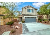 Two-story home featuring a gray two-car garage, tidy landscaping, and a charming stone-accented entrance at 10623 Kearney Mountain Ave, Las Vegas, NV 89166