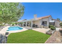 Gorgeous backyard featuring a sparkling pool, covered patio, and lush landscaping at 2738 Sandalwood Ave, Henderson, NV 89074