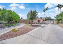 Charming single-story home with a circular driveway, mature trees, and secure gated entrance at 3753 Meadowcrest Dr, Las Vegas, NV 89121