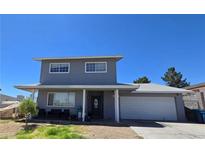 Two-story home featuring a gray exterior, covered porch, and a two-car garage on a sunny day at 4291 Powell Ave, Las Vegas, NV 89121