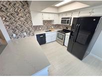 Bright kitchen boasts white cabinetry, quartz countertops, stainless steel appliances, and stylish backsplash at 435 Mesa Blvd # 202, Mesquite, NV 89027
