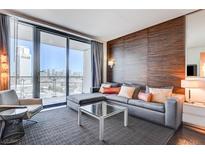 Modern living room featuring a comfortable gray sofa, glass coffee table, and a view of the Palms Casino Resort at 4381 W Flamingo Rd # 1512, Las Vegas, NV 89103