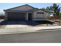Single-story home featuring a two-car garage, desert landscaping, and a neutral color palette at 5363 S Juneau St, Pahrump, NV 89061