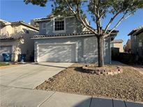 Charming two-story home features a two-car garage, desert landscaping and mature shade tree in front yard at 6063 Peach Orchard Rd, Las Vegas, NV 89142