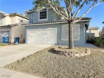 Charming two-story home featuring a well-maintained front yard with a two car garage and desert landscaping at 6063 Peach Orchard Rd, Las Vegas, NV 89142