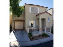 Charming two-story home featuring a front porch, attached garage, and desert landscaping at 6283 Lapilli Ave, Las Vegas, NV 89139