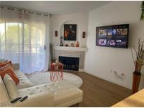 Modern living room with fireplace, sleek flooring, and a comfortable white couch perfect for relaxing and entertaining at 7885 W Flamingo Rd # 2129, Las Vegas, NV 89147