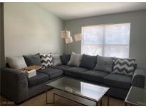 Bright living room with a large sectional sofa and a modern glass coffee table at 8101 W Flamingo Rd # 2110, Las Vegas, NV 89147