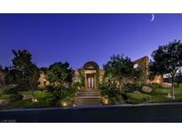 Stately home exterior featuring mature landscaping, stone accents, and a grand entrance under a moonlit sky at 15 Golden Sunray Ln, Las Vegas, NV 89135