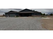Ranch style home featuring a two-car garage and low maintenance rock landscaping at 1830 Justine Ct, Pahrump, NV 89048