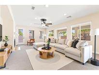 Bright living room featuring a large sectional couch, ceiling fan, and natural light from multiple windows at 2755 Asgard Ave, Las Vegas, NV 89121