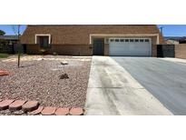 Modest home featuring a two-car garage, desert landscaping, and a long driveway at 4200 Via Vaquero Ave, Las Vegas, NV 89102