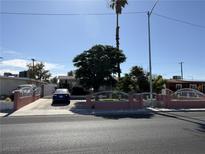 Charming single-story home featuring mature trees, a well-maintained yard, and a driveway with a parked car behind a low fence at 4567 S Nellis Blvd, Las Vegas, NV 89121