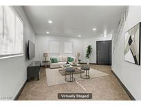 Bright living room featuring neutral colors, a plush sofa, and modern decor, virtually staged at 538 Kristin Ln, Henderson, NV 89011