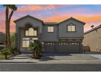 Stunning two-story home with a three-car garage and beautiful stone accents against a vibrant sunset at 691 Vineland Ave, Henderson, NV 89052