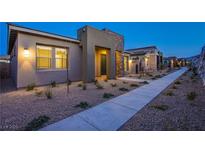Charming single-story home featuring neutral color palette, stone accents, desert landscaping, and a welcoming entryway at 909 Allister Fields Ln, Las Vegas, NV 89138