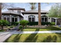 Stunning two-story home featuring lush landscaping, a stone pathway, and a well-manicured lawn at 9325 Canyon Classic Dr, Las Vegas, NV 89144