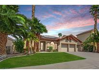 Charming home with a well-manicured lawn, mature palm trees, and a two-car garage at 1324 European Dr, Henderson, NV 89052